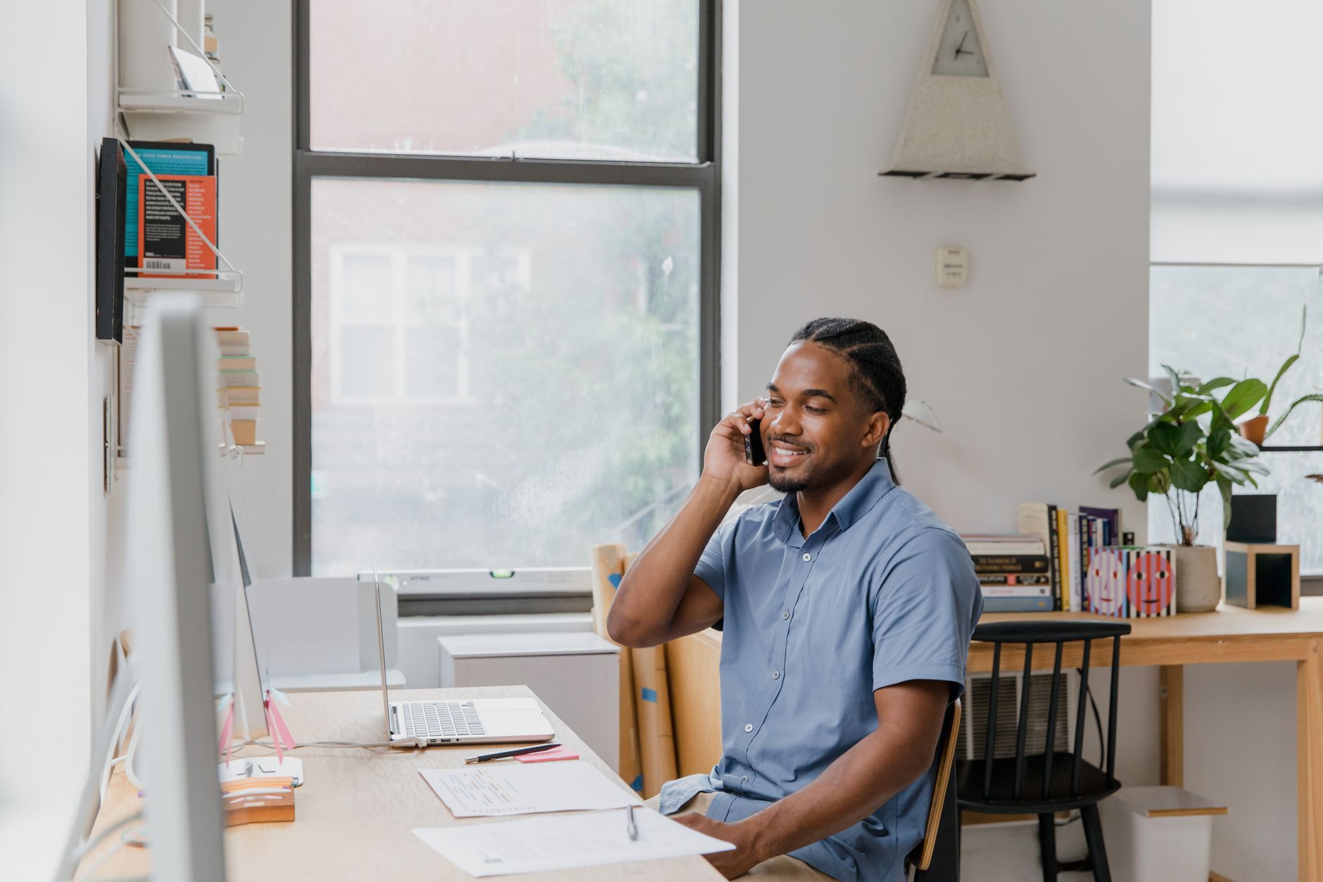 Small business owner responding to customer messages on laptop and mobile phone